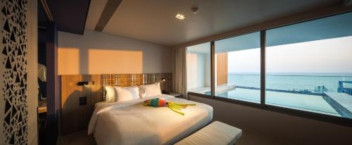 乔木提恩海滩Veranda Resort Pattaya - MGallery by Sofitel的一间卧室设有一张床,享有海景