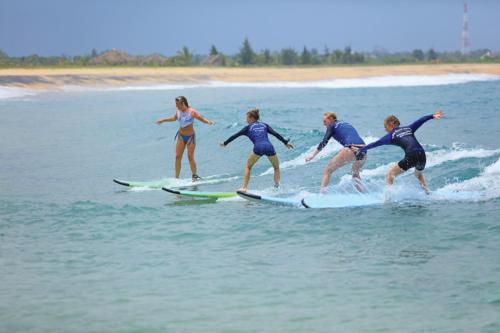 阿鲁甘湾Star Rest Beach Hotel的一群人在海洋里骑冲浪板