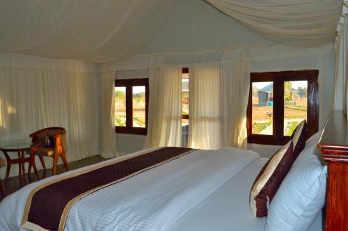 BeraThour Nature Resort - Jawai Leopard Safari Camp的卧室设有一张带窗户的白色大床
