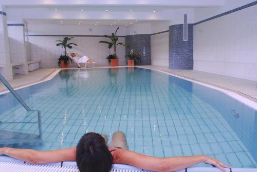 格洛米茨Hotel Strandidyll的躺在游泳池边的女人