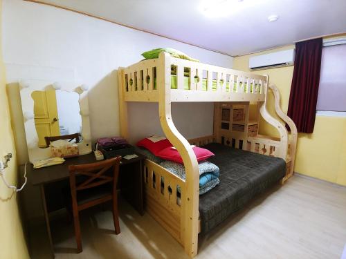 大田大田天空花园旅馆的一间卧室配有一张双层床、一张桌子和一张书桌。