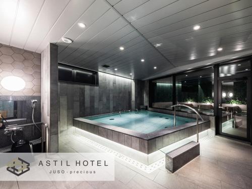大阪Astil Hotel Juso Precious的中间设有带浴缸的大浴室