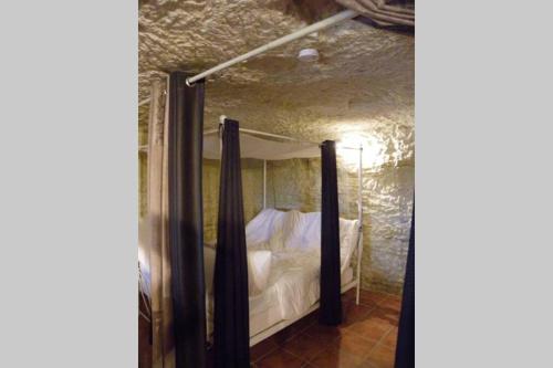 NazellesLes Hauts de Nazelles的石头间内一间卧室,配有一张床