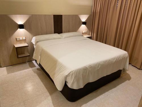 Ontígola帕拉达酒店的一间卧室配有一张带两盏灯的大型白色床。