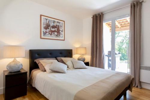 勒鲁雷Côte d'Azur, Villa New Gold Dream with heated and privat pool, sea view的一间卧室设有一张大床和一个窗户。