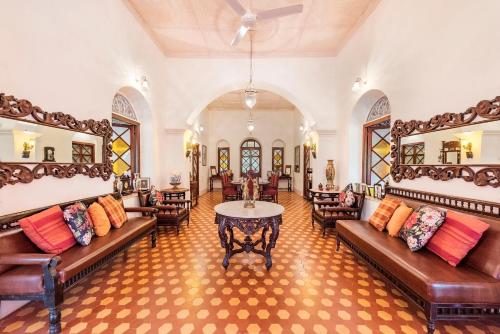 马泰兰SaffronStays Parsi Manor, Matheran的客厅配有沙发和桌子