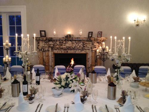 泰恩河畔纽卡斯尔Otterburn Castle的一张为婚礼准备的餐桌,壁炉