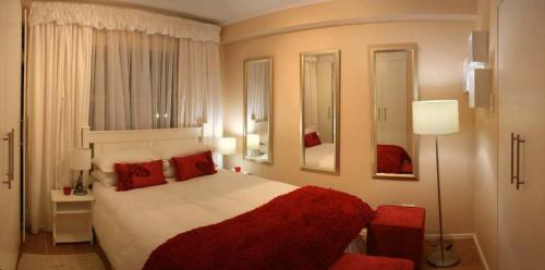 德班洛基亚凯特威公寓酒店的一间卧室配有一张带红色枕头的大床