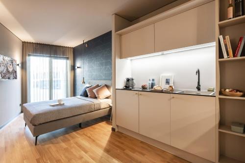 美因河畔法兰克福ipartment Frankfurt Airport的一间卧室配有一张床,厨房配有水槽