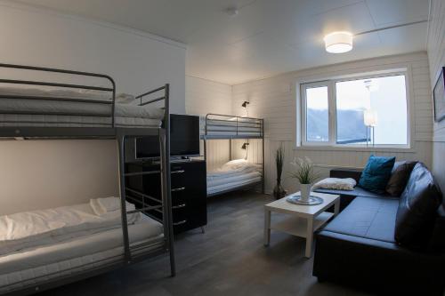 BergNorthern Light Hotell/Camp Steinfjord的一间带双层床和沙发的客厅