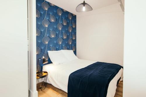 圣纳泽尔Studio Méan near Airbus and Chantiers Atlantique - wifi - parking的一间卧室配有一张蓝色墙壁的床