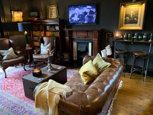 爱丁堡梅菲尔德23号酒店的客厅设有真皮沙发和壁炉