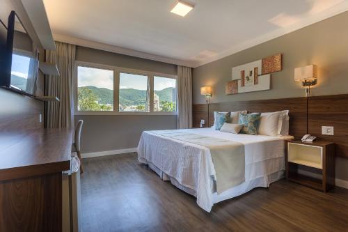 波苏斯-迪卡尔达斯Hotel Villa Fiori的酒店客房设有床和窗户。