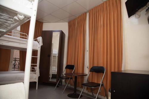 阿姆斯特丹吉米酒店的客房设有双层床、两把椅子和一张桌子。