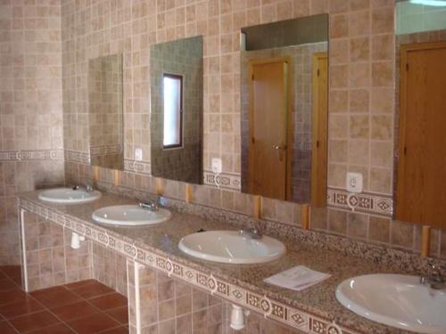 TrujillanosALBERGUE TURÍSTICO DE CORNALVO的浴室里一排水槽,有三面镜子
