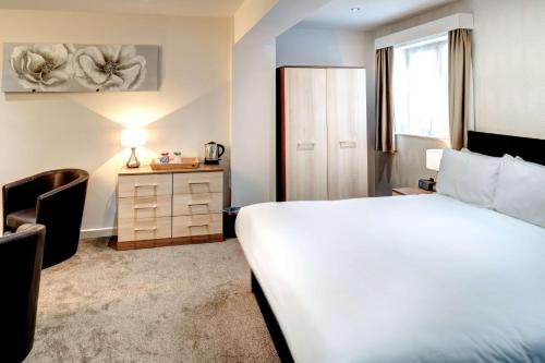 韦茅斯韦茅斯伦勃朗贝斯特韦斯特酒店 的酒店客房配有一张床、一张桌子和一把椅子。