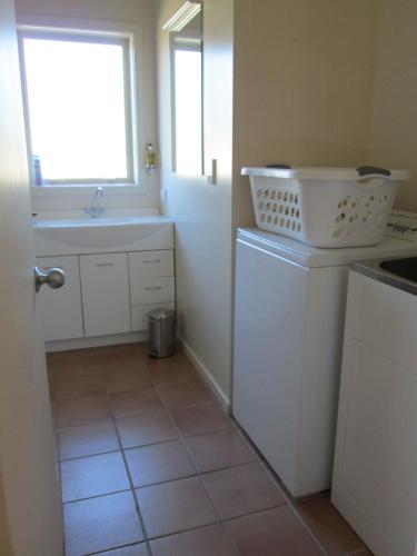 特威泽尔格莱斯顿小木屋度假屋的厨房配有水槽和洗衣机