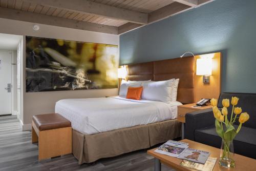 戴维斯Prodigy Hotel, a Days Inn by Wyndham的酒店客房设有一张大床和一张书桌。