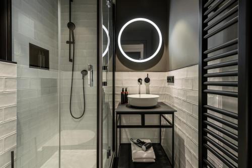 巴登-巴登THE ADAMS - Self Check In Hotel的浴室配有盥洗盆和带镜子的淋浴
