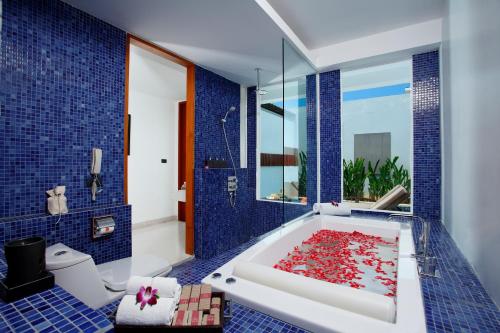芭东海滩La Flora Resort Patong - SHA Extra Plus的一间带浴缸的浴室,里面装满了红鱼