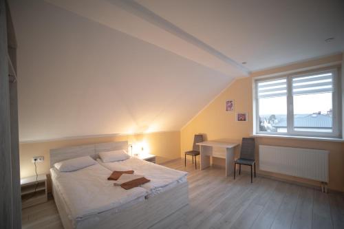 利沃夫Green Hill的一间卧室配有一张床、一张书桌和一个窗户。