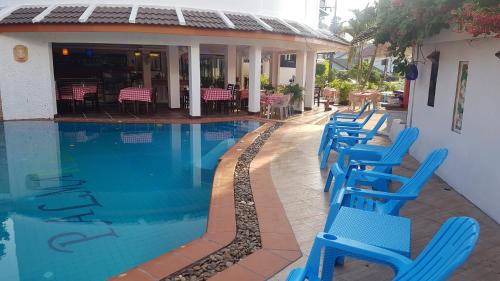 芭东海滩La Capannina Hotel Patong的游泳池旁的一排蓝色椅子