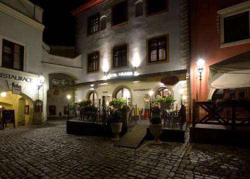 捷克克鲁姆洛夫格兰酒店的街上的一座建筑,晚上有灯