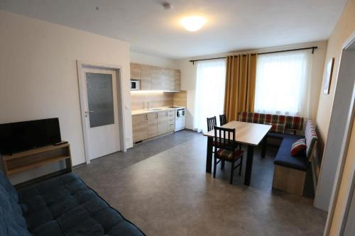 博兹达尔Apartmány AURA的带沙发和桌子的客厅以及厨房。