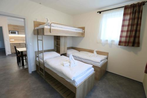博兹达尔Apartmány AURA的客房设有两张双层床和一张桌子。