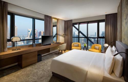 迪拜Millennium Place Barsha Heights Hotel的酒店客房配有一张床和一张书桌及一台电视