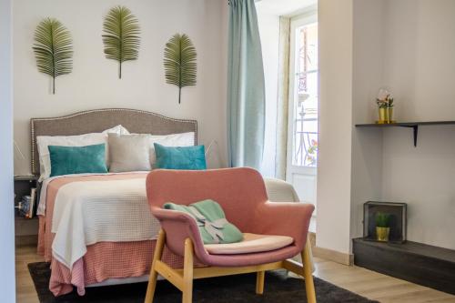 波尔图BF Suites & Apartments的一间卧室配有一张床和一张粉红色的椅子