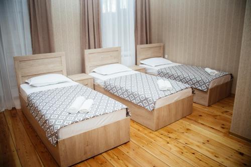 泰拉维Dreamland Guest House的铺有木地板的客房内的三张床