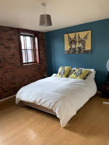 利物浦2 Bed Duplex Penthouse Apartment by Mathew Street Sleeps 6的卧室配有白色大床和蓝色的墙壁