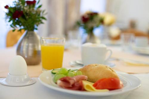 韦特海姆Hotel am Malerwinkel的桌上的一盘食物,加上一杯橙汁