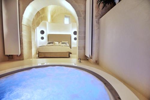 马泰拉Anima Pietra Luxury Suite的卧室中间设有大浴缸