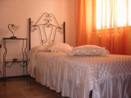 穆罗莱切塞Il Melograno的一间卧室配有一张带白色床单的床和一扇窗户。