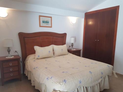 洛思坎加约斯Vivienda Vacacional la Palmera的一间卧室配有一张带2个床头柜的大床