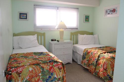 默特尔比奇美特尔海滩度假酒店的一间卧室配有两张床和一张带台灯的桌子