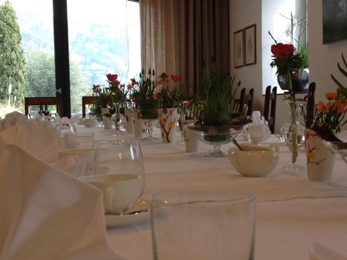 拉古多Frühmesserhaus Refugium zu Sanct Kassian的一张长桌,上面有白色的菜肴和鲜花