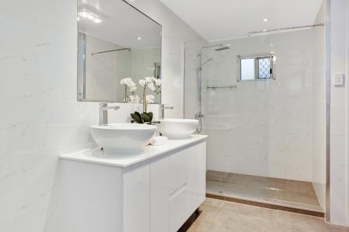 土乌巴Nell's Place的白色的浴室设有2个盥洗盆和淋浴。