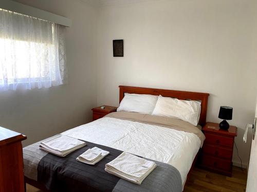 杰拉尔顿沃尔戴克海兹公寓的一间卧室配有一张床,上面有两条毛巾