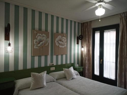 阿维拉唐迭戈旅馆的一间卧室设有一张床和绿色白色条纹墙