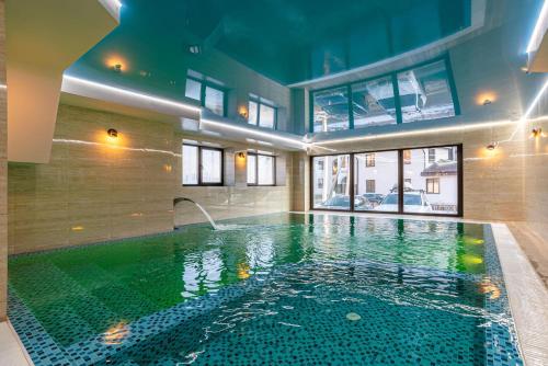 布克维Amarena SPA Hotel - Breakfast included in the price Spa Swimming pool Sauna Hammam Jacuzzi Restaurant inexpensive and delicious food Parking area Barbecue 400 m to Bukovel Lift 1 room and cottages的游泳池,位于带泳池导览器的建筑内