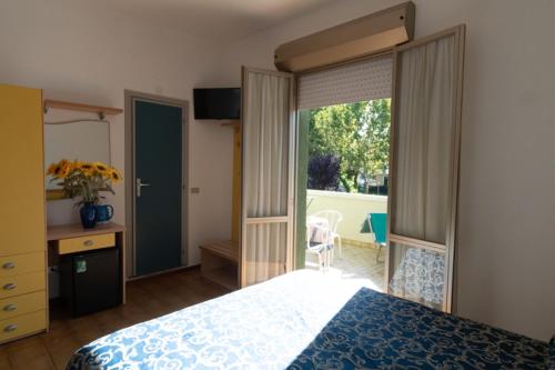 里乔内Hotel Etna的一间卧室设有一张床和一个滑动玻璃门