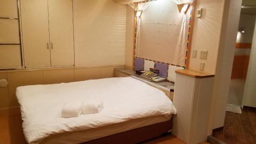 横滨Hotel GOLF Yokohama (Adult Only)的小房间,配有床和两条毛巾