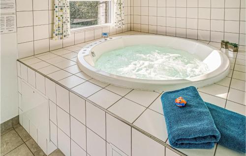 霍如帕Gorgeous Home In Sydals With Indoor Swimming Pool的一间带大浴缸及蓝毛巾的浴室