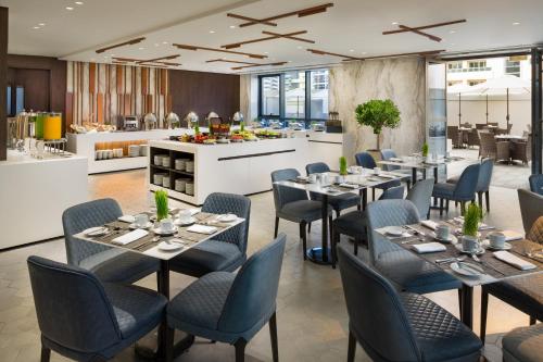 迪拜Millennium Place Barsha Heights Hotel Apartments的一间带桌椅和柜台的餐厅