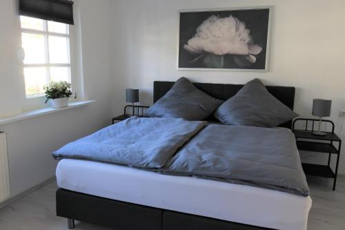 鲁尔河畔米尔海姆Ferienwohnung Villa Ruhr的一间卧室配有一张蓝色棉被的床和两个窗户