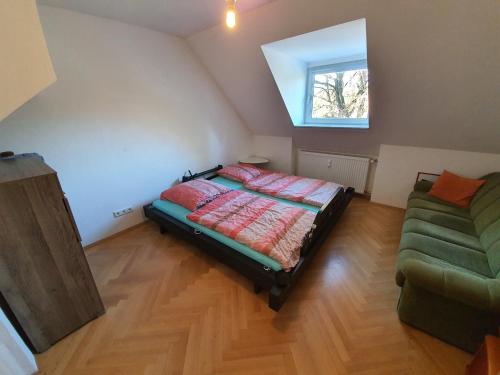 慕尼黑Idyllische Penthouse-Wohnung in super Lage的一间卧室配有一张床、一张沙发和一个窗口