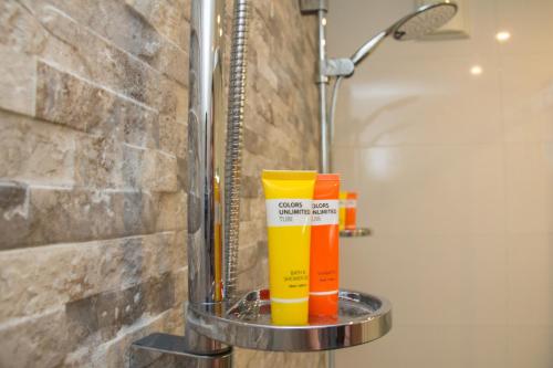 登博斯图森哈特森特杨酒店 的浴室里的架子上摆放着橙色和黄色的清洁产品